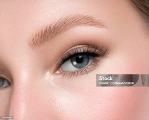 Close-up of a blue-eyed woman with natural blonde eyebrows.