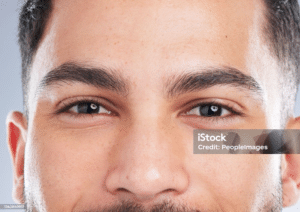 Close-up of a man’s face focusing on thick, well-groomed eyebrows.