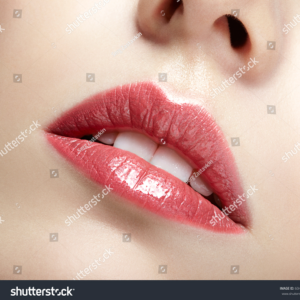 Close-up of glossy red lips after semi-permanent makeup treatment.