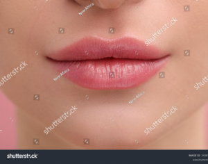 Close-up of soft pink lips after lip blushing treatment.