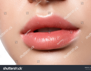 Close-up of glossy natural lips after lip blushing treatment.