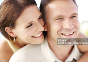 Happy middle-aged couple laughing together outdoors.