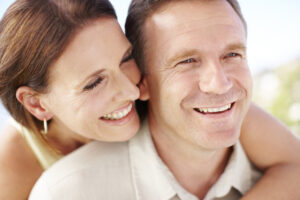 Happy middle-aged couple smiling outdoors.